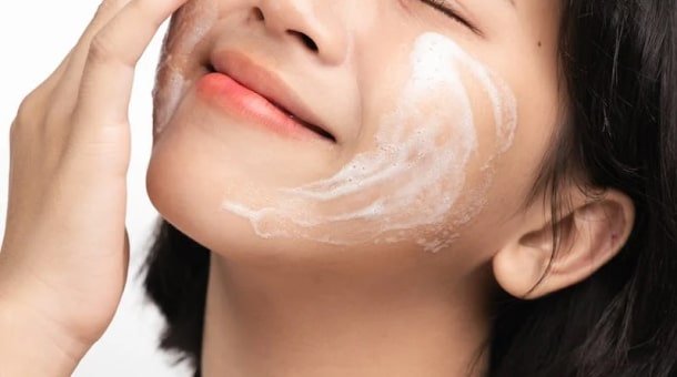 Femme appliquant une crème sur son visage
